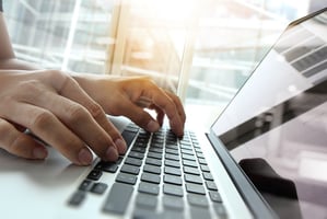 hands typing on a laptop