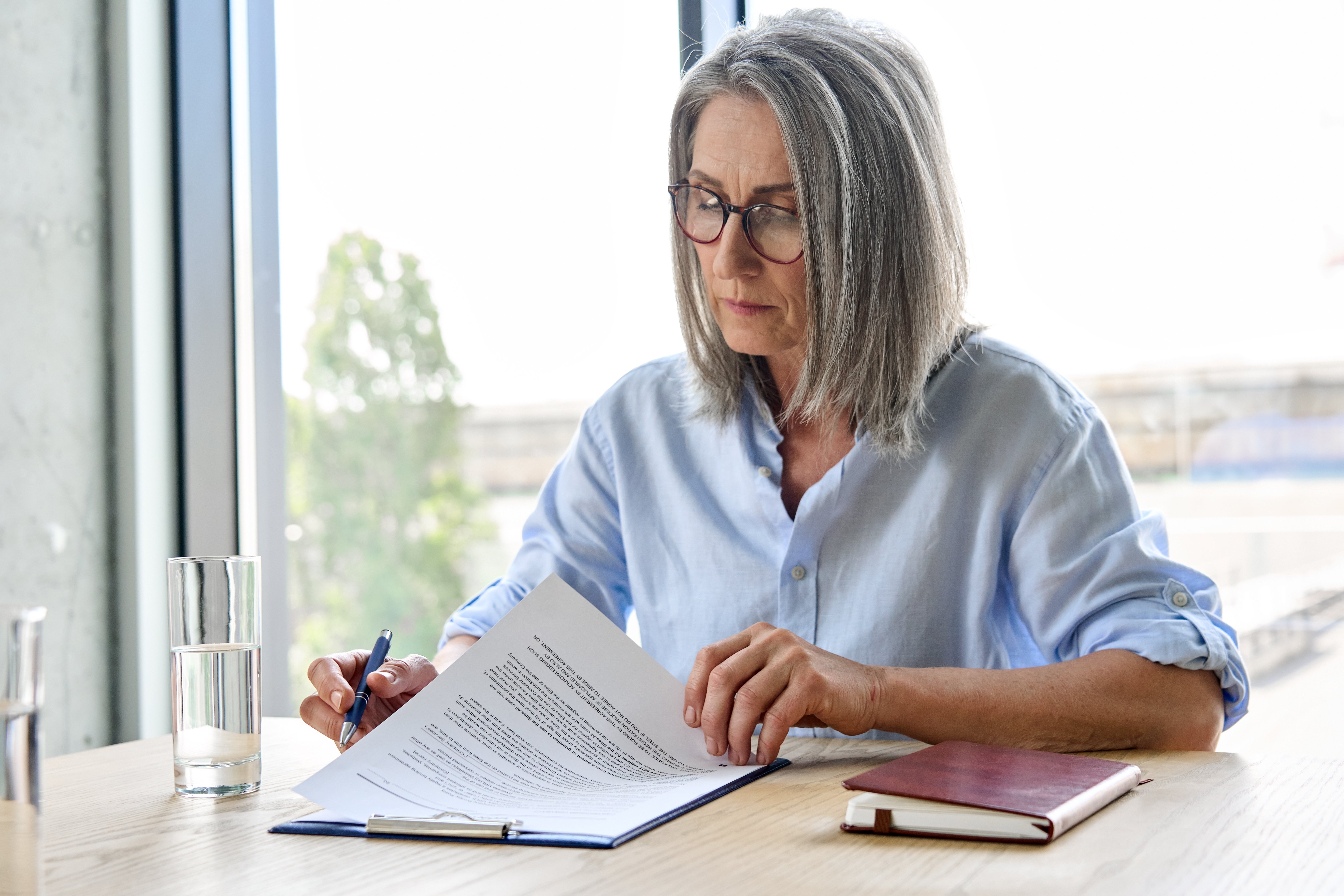 Professional reviewing documents during a defense consultation regarding employment practices.
