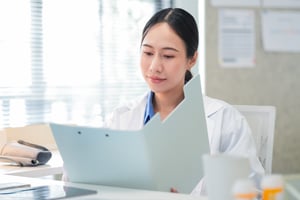 asian female doctor holding medical file