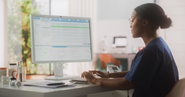 black woman looking at a computer screen and typing