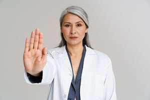 female doctor gesturing and holding up her hand
