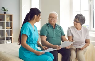 young woman nurse discussing informed consent with two older patients holding papers