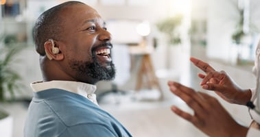 black man with hearing aid smiling