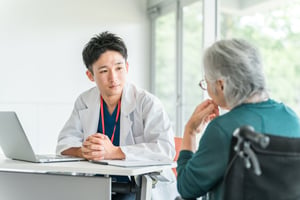 asian doctor looking at an elderly patient