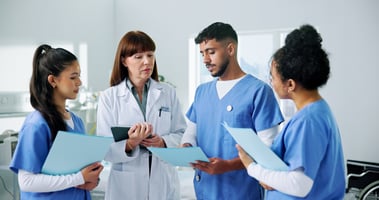 group of doctors reviewing paper reports and plans